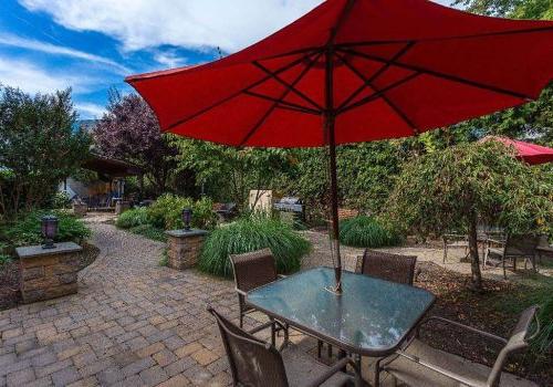 Outdoor seating area with tables and red umbrellas at 港威塔 at Packer Park apartments